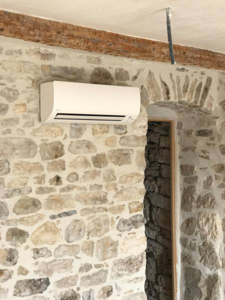 Technicien Lunapac installant une climatisation Daikin réversible dans une maison à Orange